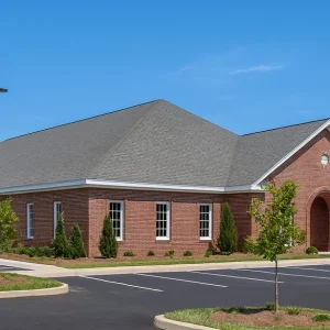 red building with parking lot and trees